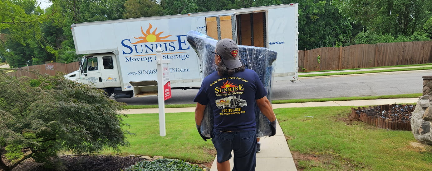 a sunrise moving & storage crew member brings furniture to a truck